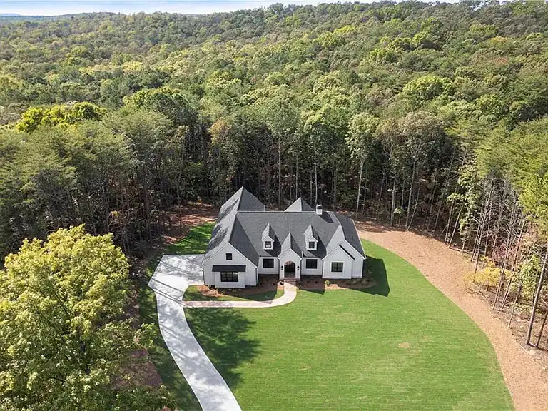 1fa1734dc0fa1e2feba5bf3734b080e4-cc_ft_768 Beautiful custom house surrounded by lush forest and green lawn, elegant architecture with a picturesque setting.