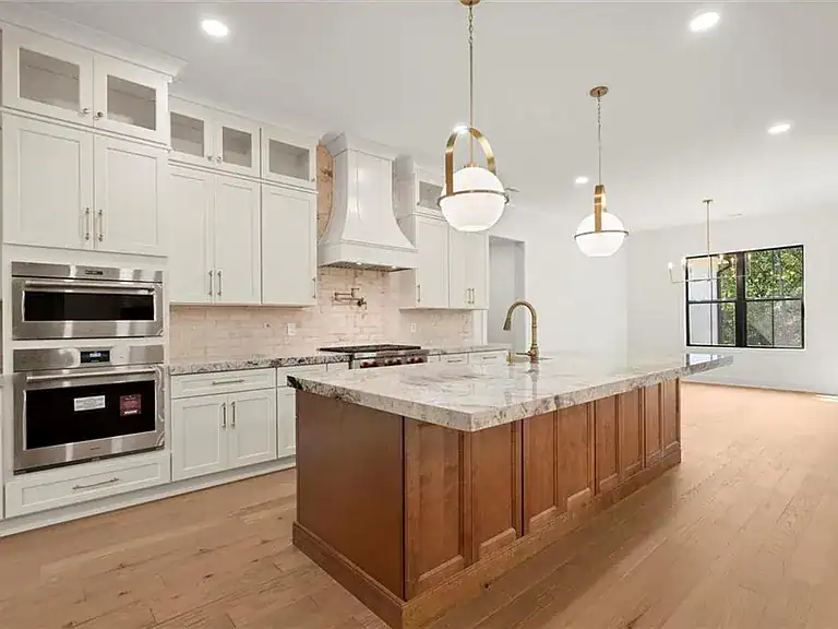 402e7b17be35b451ea7388c5e4797de3-cc_ft_768 Modern kitchen with white cabinetry and a large central island featuring a marble countertop.