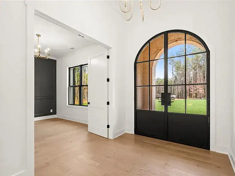 b67c4d62fe6022f2890cb8a06c37e3e2-cc_ft_768 Modern interior of a residential home with large arched glass door and window, showcasing luxury real estate design.