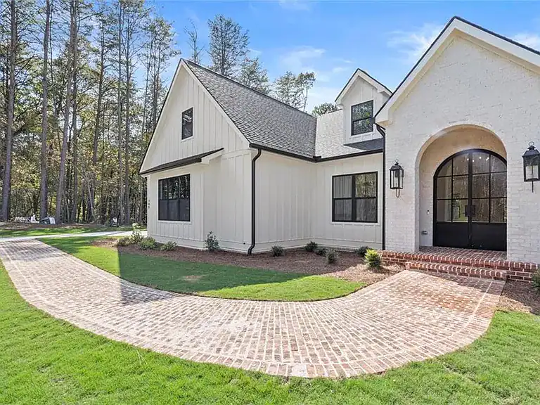 c672b6af945d30542a57c164f1e7fdee-cc_ft_768 Modern farmhouse style home with white exterior and brick pathway.